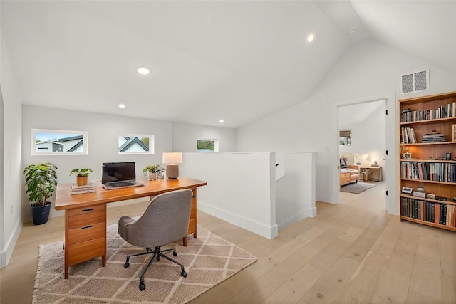 office space with vaulted ceiling and light hardwood / wood-style flooring