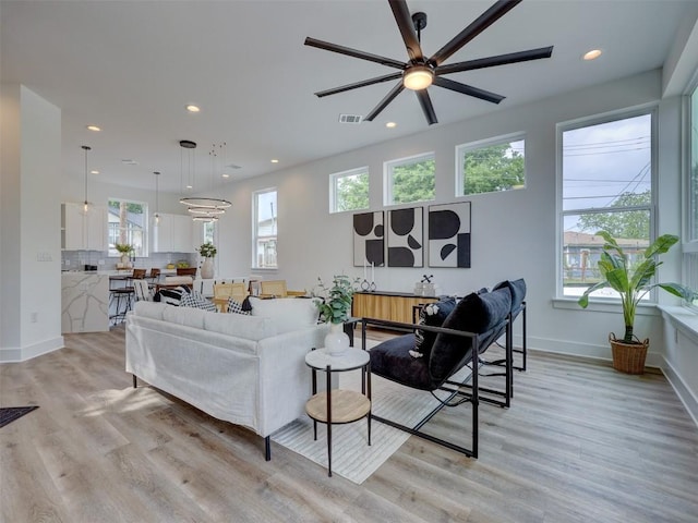 living room with ceiling fan and light hardwood / wood-style flooring