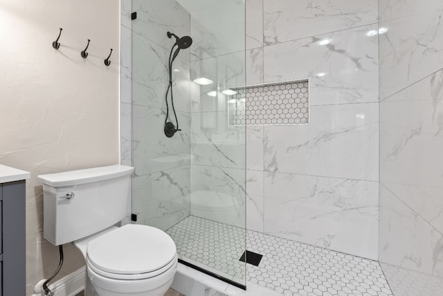 bathroom featuring vanity, toilet, and tiled shower