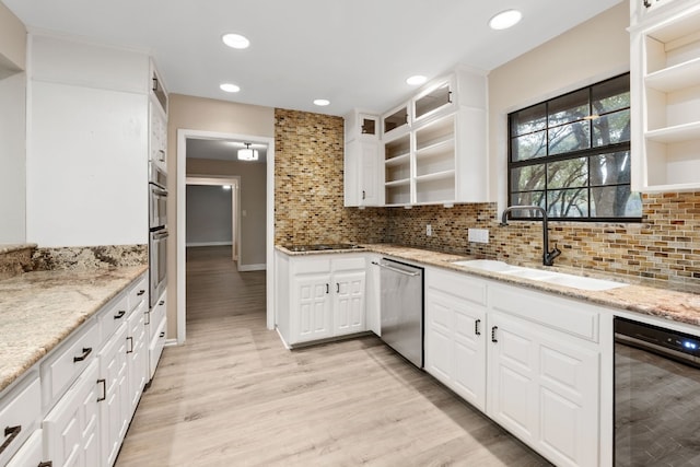 kitchen with light stone counters, sink, white cabinets, and stainless steel appliances