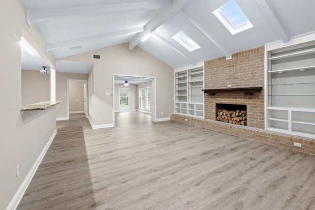 unfurnished living room with hardwood / wood-style flooring, ceiling fan, lofted ceiling with skylight, and a fireplace