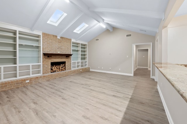 unfurnished living room featuring lofted ceiling with skylight, a fireplace, and light wood-type flooring