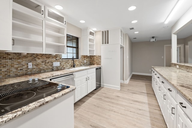 kitchen with black cooktop, light stone counters, sink, light hardwood / wood-style flooring, and white cabinetry