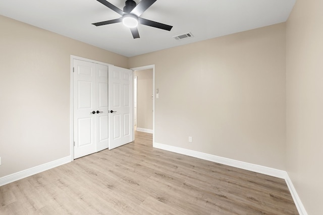 unfurnished bedroom with a closet, light hardwood / wood-style floors, and ceiling fan