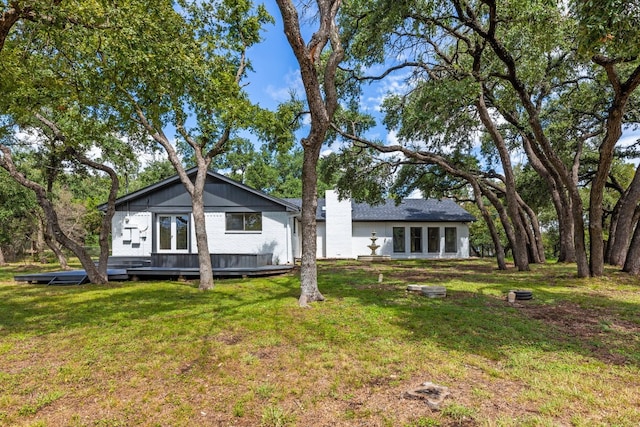 rear view of property with a yard and a deck