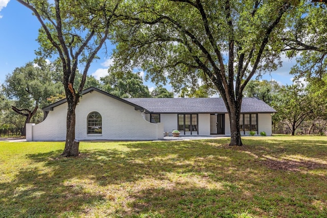 single story home featuring a front lawn