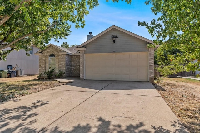 ranch-style home with central AC unit and a garage