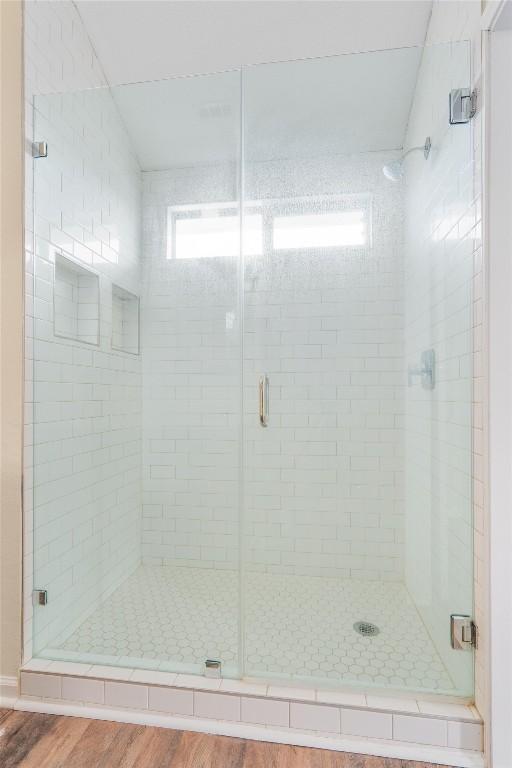 bathroom featuring wood-type flooring and a shower with door