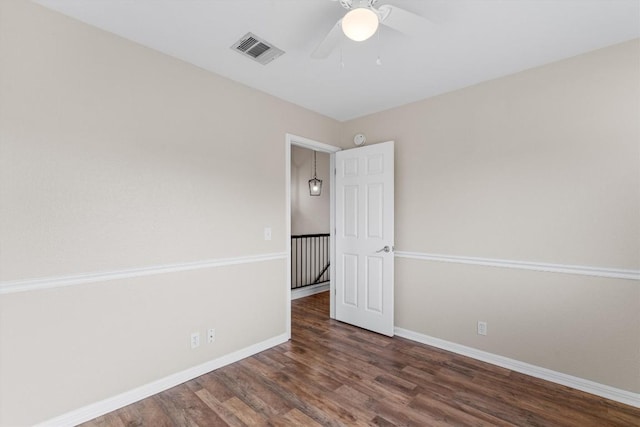 unfurnished room with ceiling fan and dark wood-type flooring