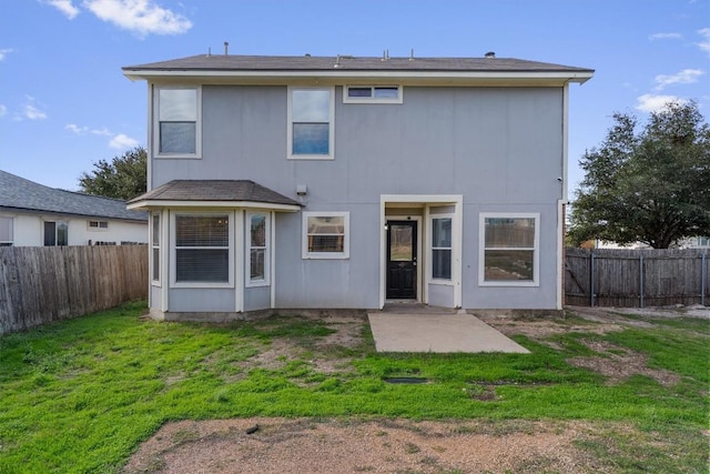 rear view of house featuring a patio area and a yard