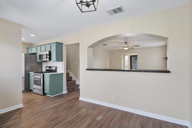 kitchen with stainless steel appliances, ceiling fan, and dark wood-type flooring