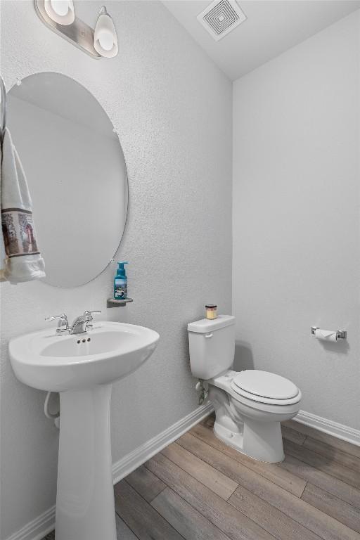 bathroom featuring hardwood / wood-style floors and toilet