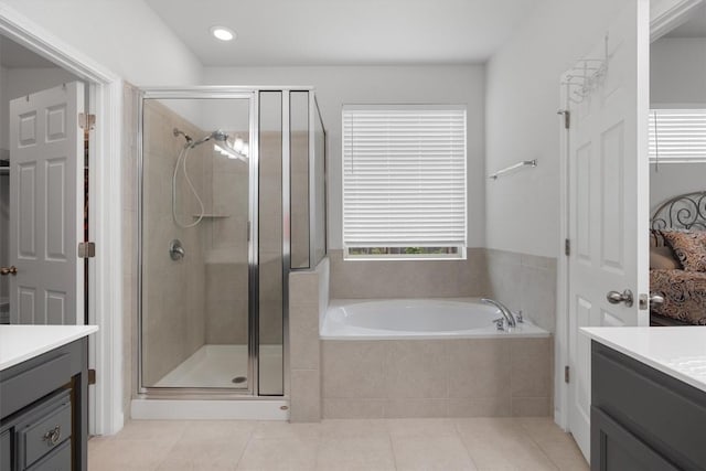 bathroom with tile patterned floors, vanity, and shower with separate bathtub