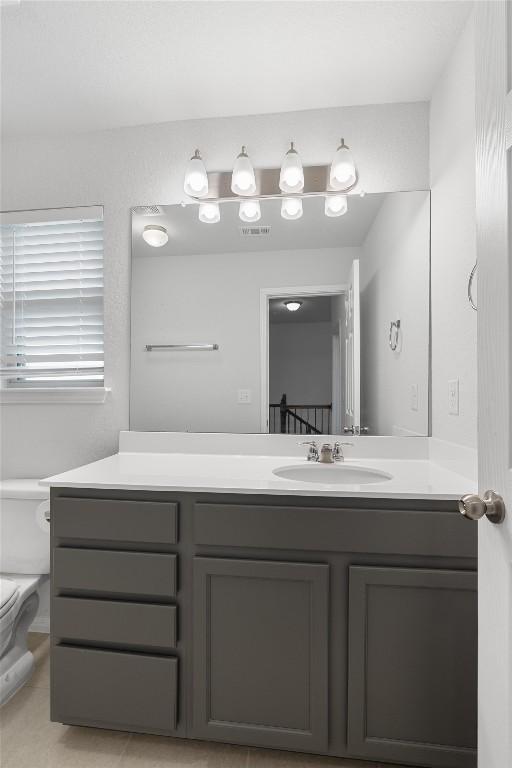 bathroom featuring tile patterned flooring, vanity, and toilet