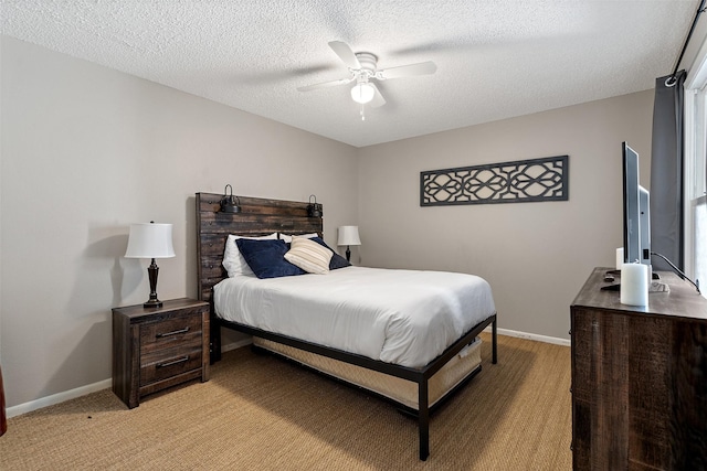 carpeted bedroom featuring ceiling fan and a textured ceiling