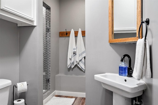 106 Center Cove Ii Loop, Spicewood, TX 78669 - bathroom with toilet, a stall shower, wood finished floors, a sink, and baseboards