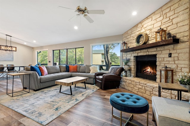 living room featuring lofted ceiling, wood-type flooring, a fireplace, and ceiling fan