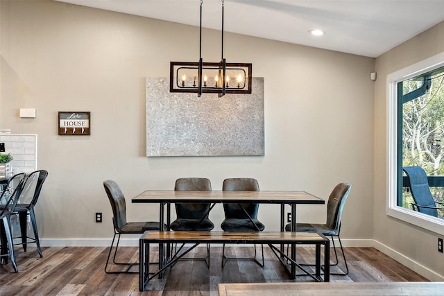 dining area featuring lofted ceiling, a healthy amount of sunlight, a notable chandelier, and dark wood-type flooring