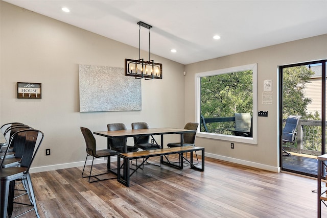 dining area featuring a healthy amount of sunlight, vaulted ceiling, and hardwood / wood-style floors