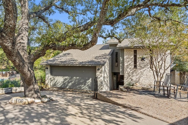 106 Center Cove Ii Loop, Spicewood, TX 78669 - view of front of home with an attached garage, roof with shingles, concrete driveway, and brick siding