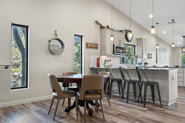 106 Center Cove Ii Loop, Spicewood, TX 78669 - dining room featuring wood finished floors, high vaulted ceiling, baseboards, and recessed lighting