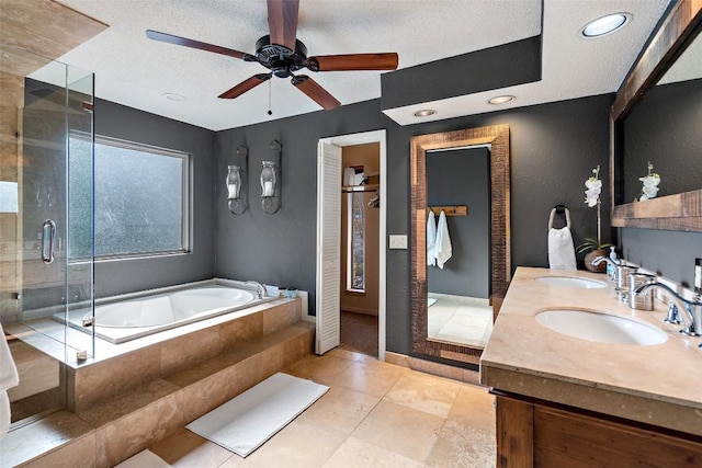 106 Center Cove Ii Loop, Spicewood, TX 78669 - bathroom featuring a bath, double vanity, a ceiling fan, a stall shower, and a textured ceiling