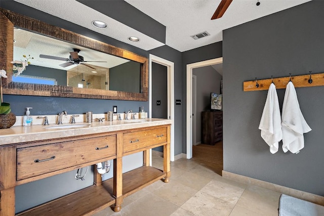 bathroom featuring ceiling fan, vanity, tile patterned flooring, and a textured ceiling