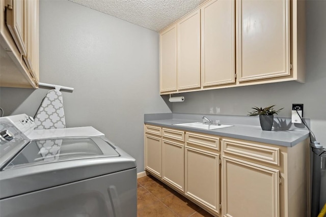 laundry area with tile patterned floors, sink, washing machine and clothes dryer, a textured ceiling, and cabinets