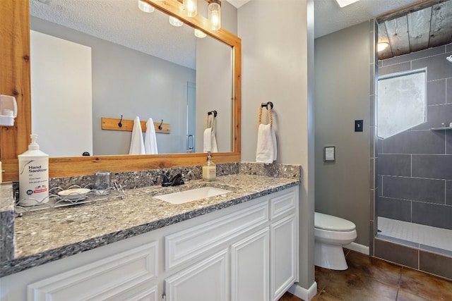 bathroom with tile patterned floors, toilet, walk in shower, and vanity