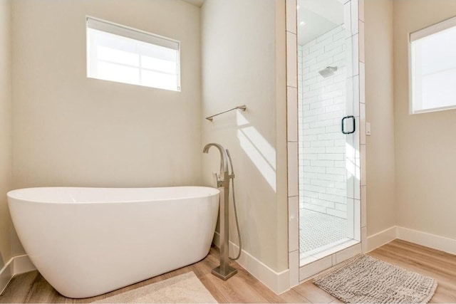 bathroom featuring hardwood / wood-style floors and separate shower and tub