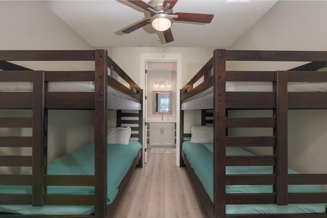 unfurnished bedroom with ceiling fan, lofted ceiling, light wood-type flooring, and ensuite bath