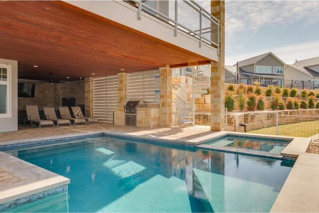 view of swimming pool featuring an in ground hot tub, a patio, grilling area, and exterior kitchen