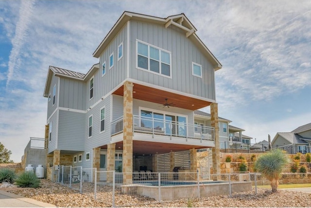 200 Archview Ln, Kingsland, TX 78639 - rear view of house featuring board and batten siding, a ceiling fan, stone siding, and a balcony