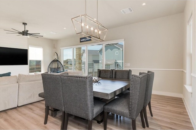 dining area featuring hardwood / wood-style floors and ceiling fan with notable chandelier