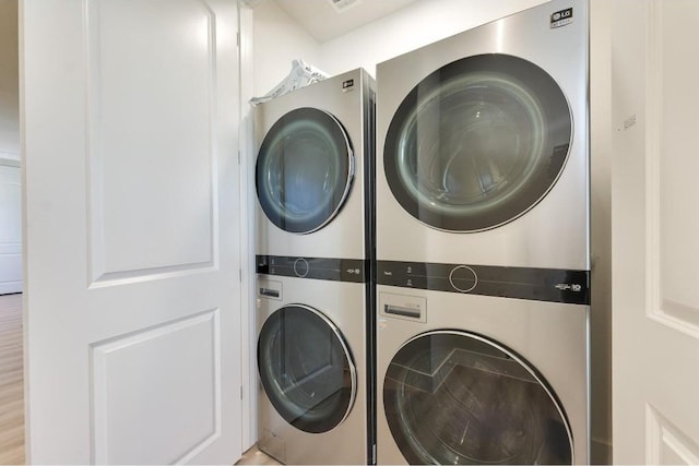 clothes washing area featuring stacked washer / dryer