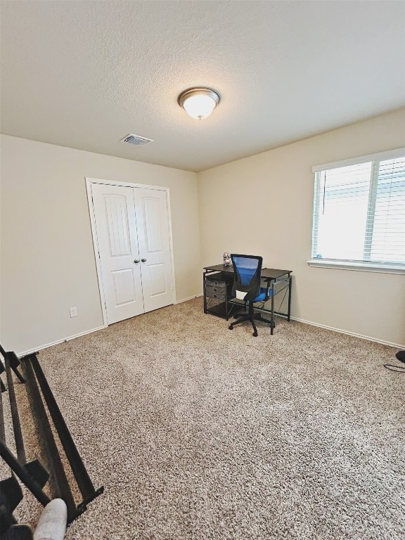 carpeted office space with a textured ceiling