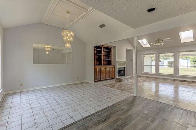 unfurnished living room featuring ceiling fan with notable chandelier, a textured ceiling, light wood-type flooring, and lofted ceiling with skylight