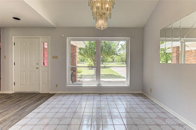 tiled foyer featuring a chandelier and a textured ceiling