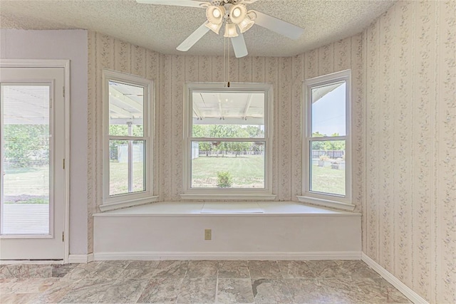 interior space featuring ceiling fan and a textured ceiling