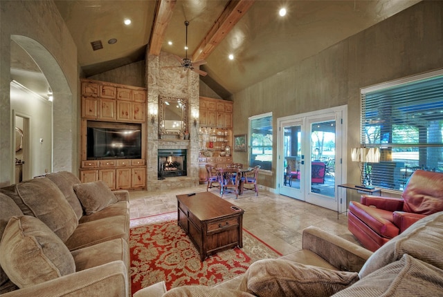 living room with ceiling fan, a fireplace, beamed ceiling, and high vaulted ceiling