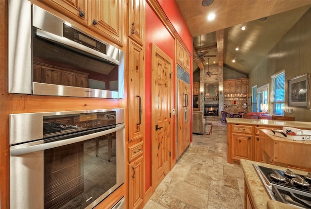 kitchen featuring lofted ceiling with beams, ceiling fan, and stainless steel gas cooktop