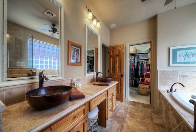 bathroom featuring vanity and a relaxing tiled tub