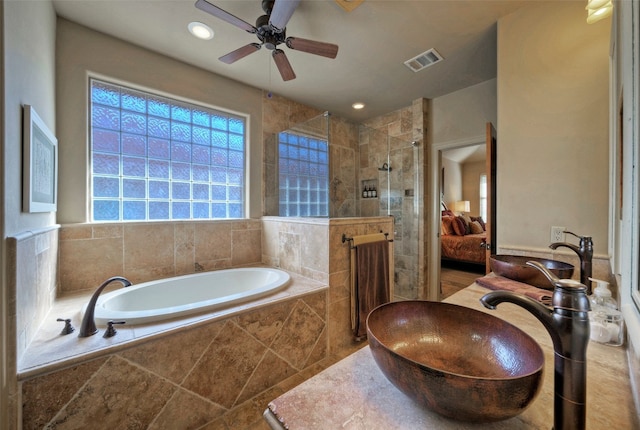 bathroom featuring plus walk in shower, ceiling fan, and sink