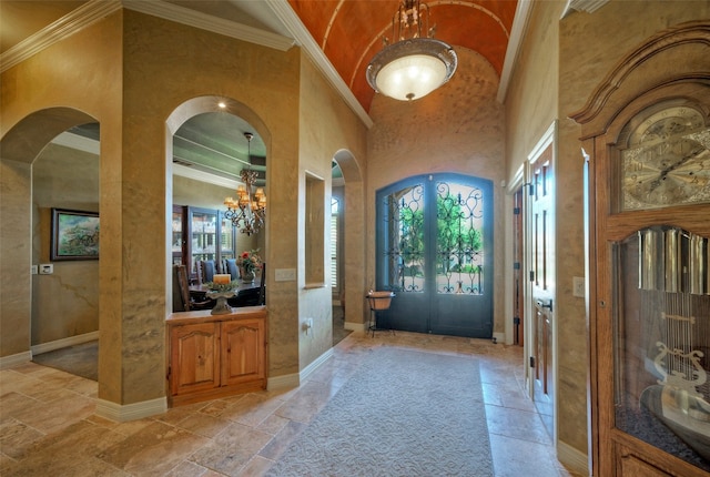 entryway with a chandelier, a high ceiling, and ornamental molding