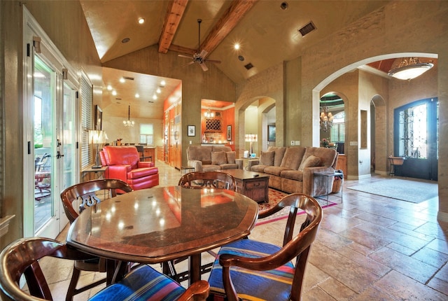 dining space featuring ceiling fan with notable chandelier, beam ceiling, and high vaulted ceiling