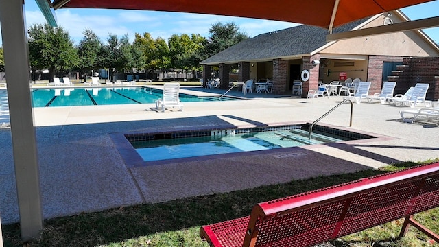 view of swimming pool with a patio and a hot tub