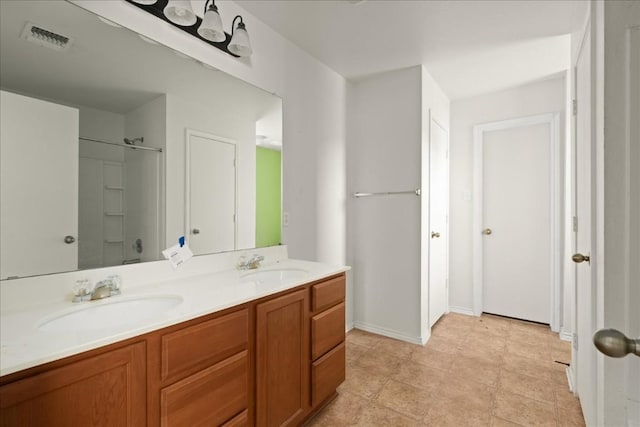 bathroom with a shower, tile patterned flooring, and vanity