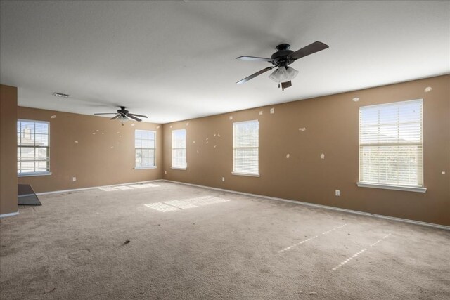 carpeted spare room with ceiling fan