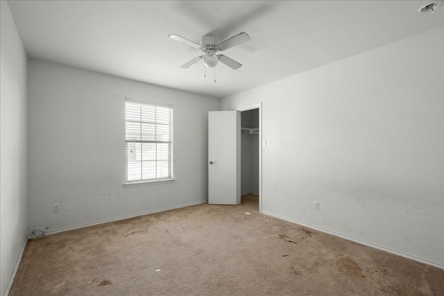 unfurnished bedroom with ceiling fan, a closet, and light carpet