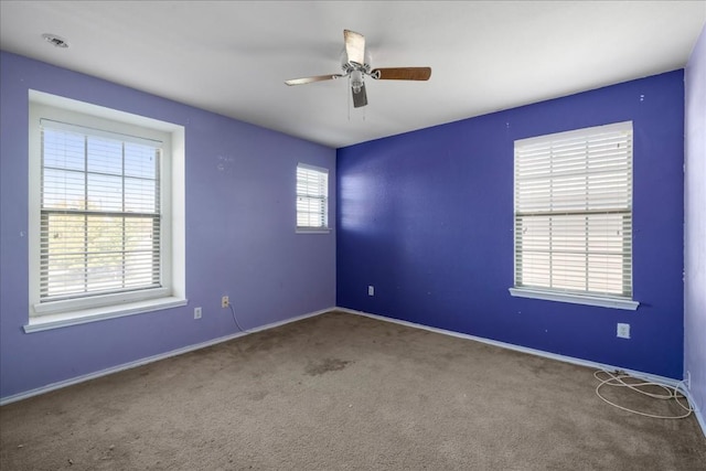 carpeted empty room with plenty of natural light and ceiling fan